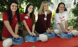 Image: Take Heart First Coast volunteers demonstrate hands-only CPR during the UF Health Jacksonville Wellness Fair.