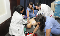 Image: Residents Esther Mihindu, MD, and Saif Ibrahim, MD, tend to a medical simulation dummy while nurses Nicole Salerno and Sara Woolsey assist during the April 8 Sim Wars competition.