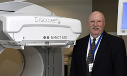 Image: Barry McCook, MD, associate professor and chair of radiology at the University of Florida College of Medicine – Jacksonville, stands beside a PET-CT scanner, one of several new imaging devices at UF Health North.