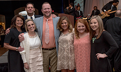 Image: Mark Taylor, in the paisley necktie, is surrounded by family and friends during the Feb. 6 A Night for Heroes gala, which benefited TramaOne at UF Health Jacksonville. Mark was recognized for his perseverance and strength, as he