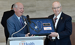 Image: UF Health Jacksonville CEO Russ Armistead, left, presents former hospital CEO Marcus E. Drewa with a token of appreciation for the leadership he