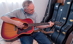 Image: Thanks to DBS treatment, John has been able to resume hobbies such as playing the guitar and woodworking.