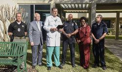Image: David Ebler, MD, medical director of TraumaOne at UF Health Jacksonville, presents Jacksonville police officer Terrance Hightower with an award honoring his heroic efforts following a recent shooting incident. Pictured from left to right are John Price, a reserve SWAT. medic and flight nurse with the Jacksonville Sheriff’s Office, UF Health Jacksonville CEO Russ Armistead, Ebler, Hightower, Marie Hightower and TraumaOne outreach coordinator James Montgomery.