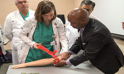 Image: Leon L. Haley Jr., MD, dean of the UF College of Medicine – Jacksonville, instructs a participant on proper tourniquet use.