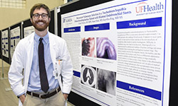 Image: Grant Nelson, DO, MPH, an internal medicine resident, stands beside his research presentation centering on recurrent pulmonary infection — one of nearly 120 poster and platform presentations that were part of Celebration of Research.