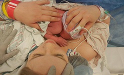 Image: Heather Fails, RN, holding her daughter Winry after undergoing a gentle C-section.