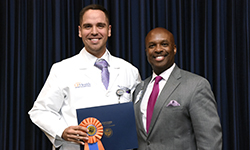 Image: Jose Rivas Rios, MD, accepts the first-place poster presentation award on behalf of Dmitry Yaranov, MD. Both are internal medicine resident physicians. Rivas Rios was a coauthor on the study.