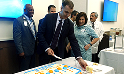 Image: Daryoush Tavanaiepour, MD, cuts and serves cake during the event.
