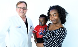 Image: Brent Seibel, MD, reunited with Marquita Troutman and Cameron Mayhew, the first baby delivered at UF Health North.