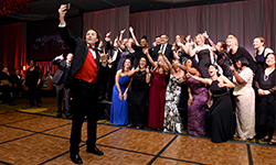 Image: Chris Hemmen takes an enthusiastic selfie during the “A Night for Heroes” gala, with many of his UF Health caregivers in the background.