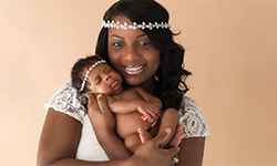 Image: La’Trece Bartley cuddles her newborn daughter, Olivia, during a photo shoot celebrating her christening day. Photo is courtesy of Sarah Hedden Photography.