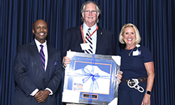 Image: Robert Luten, MD, displays his Distinguished Alumni Award.
