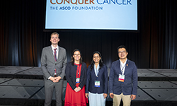 Image: Mobley stands with 2025 Merit Award recipients at the American Society of Clinical Oncology Annual Meeting.