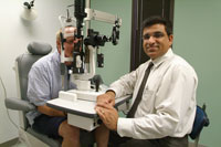 Image: Tom Harcz (left) is examined by UF researcher Sandeep Grover, M.D., one of three researchers in Florida testing an implant they hope will keep cells in the eye from deteriorating during retinitis pigmentosa.