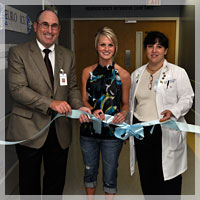 Image: Ribbon cutting at the Shands Jacksonville Neuroscience Intensive Care Unit with UF neurology Chair Dr. Alan Berger; Ashley Davis, a former trauma patient; and Dr. Miren Schinco, a UF associate professor of acute care surgery.