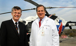 Image: Joseph Tepas III, M.D., UF professor and chief of pediatric surgery, and David Vukich, M.D., FACEP, UF professor of emergency medicine, stand before a helicopter that bears the initials of the late Raymond Alexander, M.D., considered by many to be the father of Florida